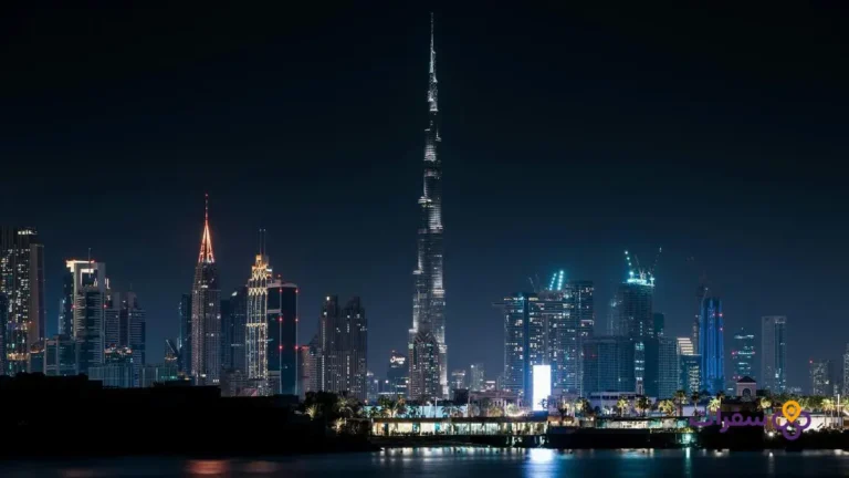 best areas stay dubai families 0 منظر بانورامي لأفق دبي ليلاً مع برج خليفة مضاء.
