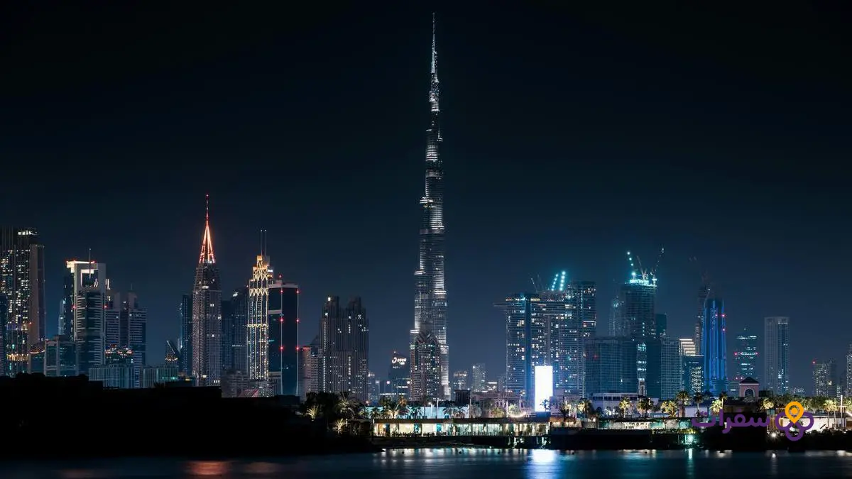 منظر بانورامي لأفق دبي ليلاً مع برج خليفة مضاء.