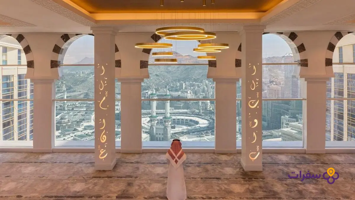 صورة فندق في مكة المكرمة مع المسجد الحرام في الخلفية، تظهر عمارة مميزة للمدينة.