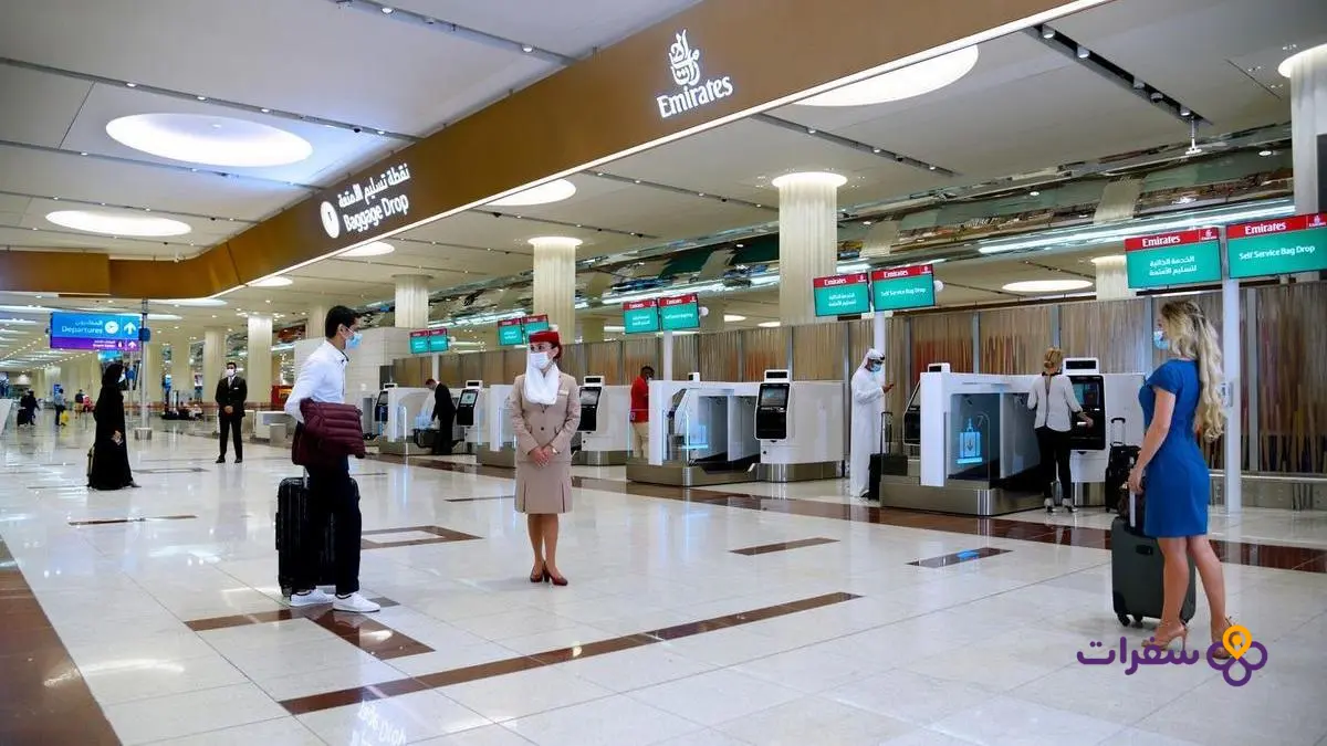 صالة الجمارك والهجرة في مطار دبي الدولي، تظهر بوابات المراقبة الإلكترونية ومناطق تفتيش الحقائب.
