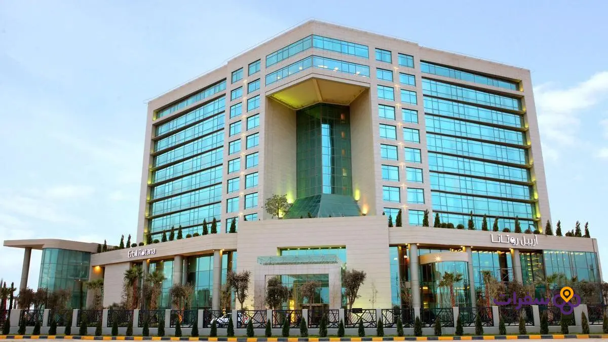 erbil tourist places travel guide 4 3 صورة خارجية حقيقية لفندق في أربيل ضمن سياق المدينة، تظهر واجهة الفندق والمنطقة المحيطة به.