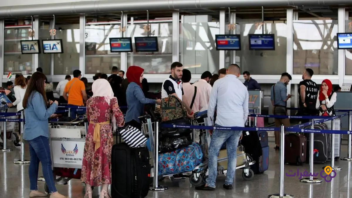 iraqi airways baggage allowance guide 1 3 صورة لمنضدة تسجيل الأمتعة في مطار عراقي، حيث يقوم موظف بمساعدة مسافر.