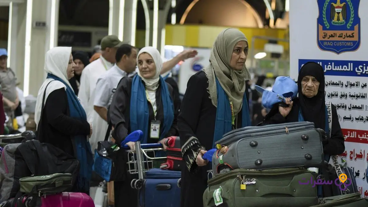 umrah from iraq guide prices 2 4 Iraqi pilgrims wearing white ihram garments presenting their passports to a passport officer at Baghdad International Airport.